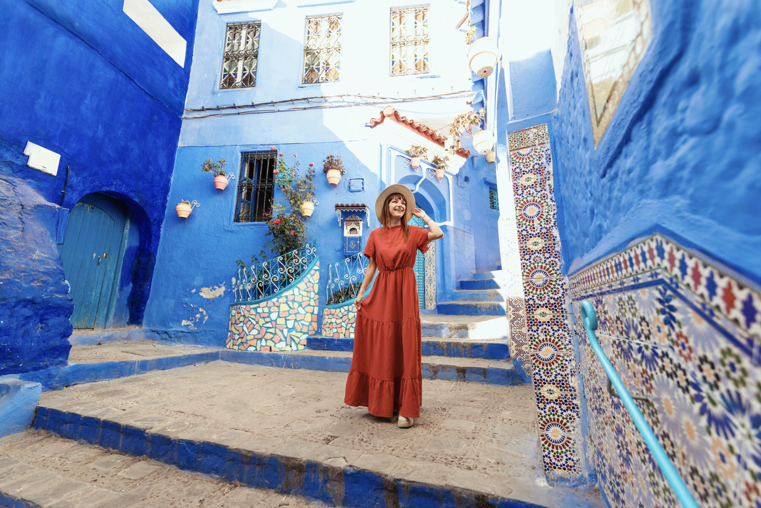 Young woman with red dress visiting the blue city Chefchaouen, M